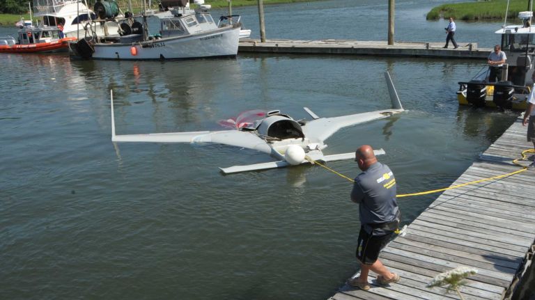 The wreckage of a single-engine plane that crashed into the Long Island Sound is towed by Seatow through the Mattituck Inlet on Monday, July 7, 2014.