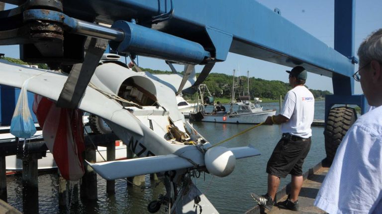 The wreckage of a single-engine plane that crashed into the Long Island Sound is towed by Seatow through the Mattituck Inlet on Monday, July 7, 2014.
