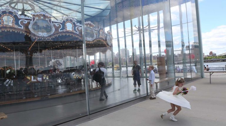 A flower girl plays in front of Jane's Carousel in Brooklyn Bridge Park in Dumbo on June 6, 2014.