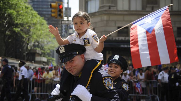 New York Police Department officer Isac Ramos carries his daughter, Kiera, 3, during the 57th annual National Puerto Rican Day Parade in Manhattan on Sunday, June 8, 2014.