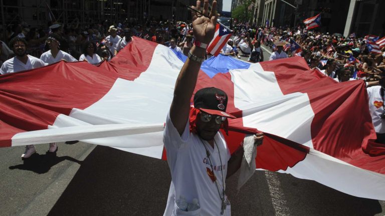 Participants march with a giant Puerto Rican flag during the 57th annual National Puerto Rican Day Parade in Manhattan on Sunday, June 8, 2014.