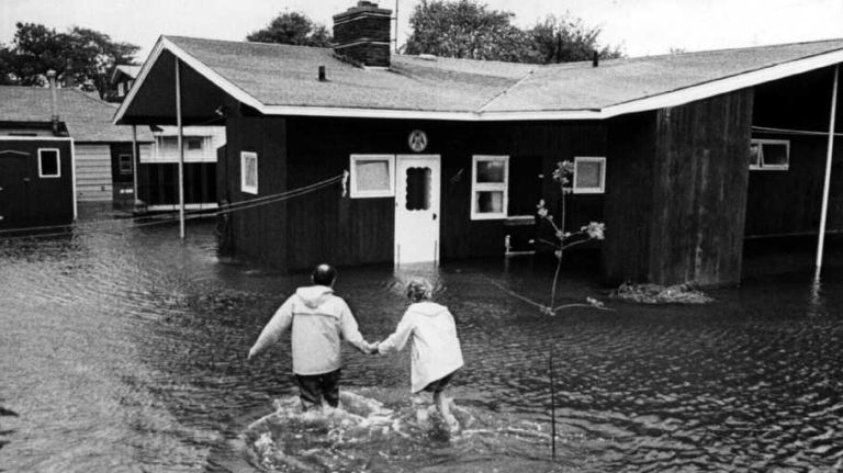 In the wake of Hurricane Gloria on Sept. 27, 1985, neighbor helps neighbor on a flooded canal on Warwick Road in Island Park.