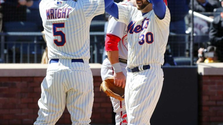 Andrew Brown celebrates his first-inning three-run home run against the Washington Nationals with teammate David Wright #5 at Citi Field on Monday, March 31, 2014.