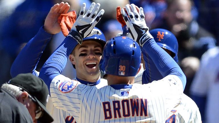 David Wright and Juan Lagares congratulate Andrew Brown after he hit a three-run home run in the first inning of a game against the Washington Nationals at Citi Field on March 31, 2014.