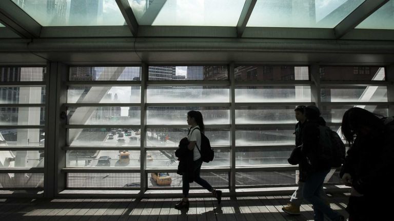 People walk over he Tribeca Bridge over West Street in TriBeCa on March 20, 2014. 