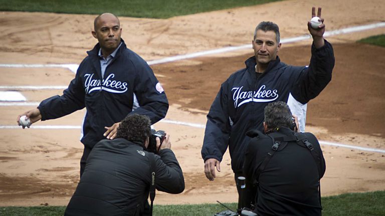 Former Yankees' pitcher Mariano Rivera and Andy Pettitte wave to the crowd after throwing out the first pitch at Yankee Stadium on April 7, 2011. 