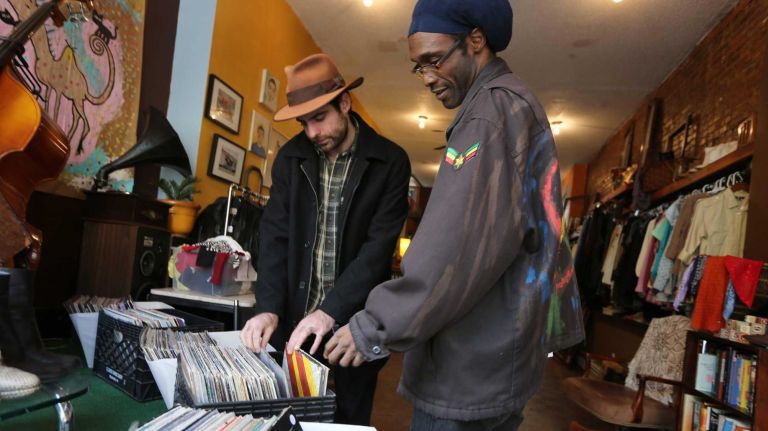 At the Cool Pony on Franklin Avenue, owner Craig Judelman, left, helps Shannon Tyler look for an album.