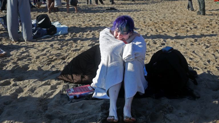 A woman warms up after running into the ocean at the Coney Island Polar Bear Club's New Year's Day Swim on Jan. 1, 2017.