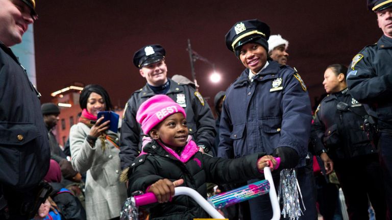 Veronika Victor, 5, of Brooklyn, sits on a new bike just given to her by NYPD officers of the 79th Precinct in Bed-Stuy on Dec. 21, 2017.