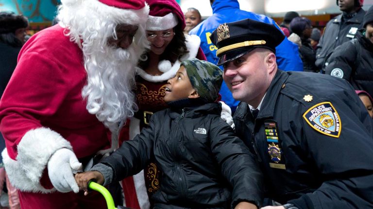 A child sits on a bike just after receiving it on Dec. 21, 2017, in the 79th Precinct in Bed-Stuy, part of the Brooklyn North's Sleigh Ride. 
