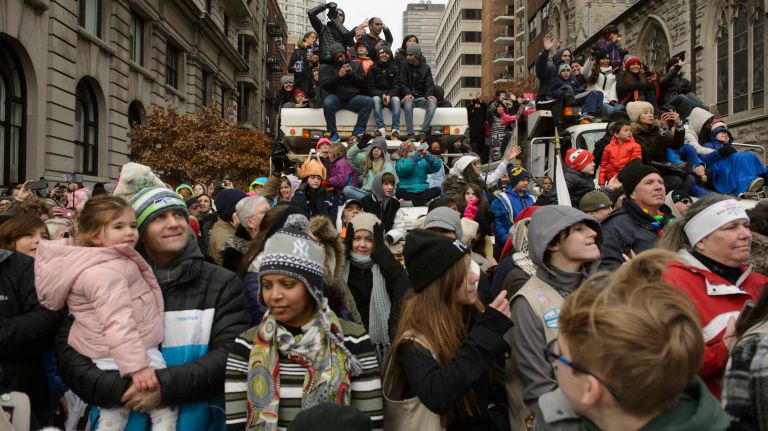 Spectators sitting on city sand trucks on Thursday, Nov. 24, 2016, watch the 90th annual Macy's Thanksgiving Day Parade. The sand trucks blocked the side streets along the parade route from Central Park West to outside the Macy's store on Herald Square.