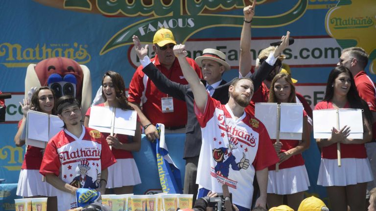 Joey Chestnut, right, defeats Matt Stonie, left, after eating 70 hot dogs during Nathan's Famous Fourth of July International Hot Dog Eating Contest in Coney Island, Brooklyn, on Monday, July 4, 2016. This year marks the 100th anniversary of the annual Fourth of July hot-dog-eating contest.