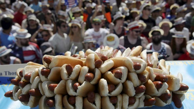 Fans cheer as they wait for the start of Nathan's Famous Fourth of July International Hot Dog Eating Contest in Coney Island, Brooklyn, on Monday, July 4, 2016. This year marks the 100th anniversary of the annual Fourth of July hot dog eating contest.