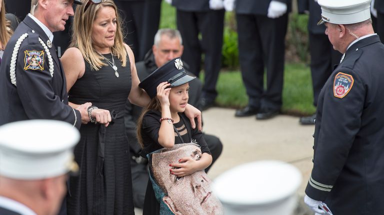 NYFD firefighter William Tolley's wife and daughter attend his funeral at St. Martin of Tours Roman Catholic Church in Bethpage on April 27, 2017.