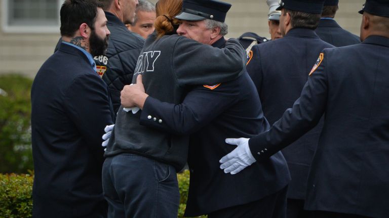 Firefighters console each other as the body of FDNY firefighter William Tolley is transferred to Chapey and Sons funeral home in Bethpage on Friday, April 21, 2017.