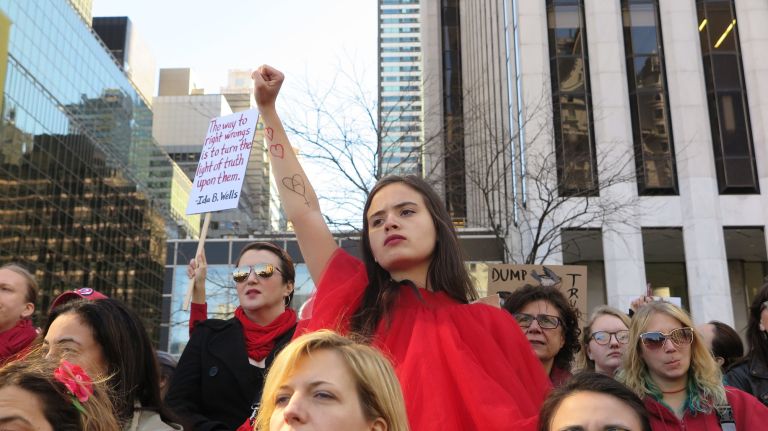 A woman thrusts her fist into the air in solidarity with the A Day Without a Woman rally in Manhattan on Wednesday, March 8, 2017.