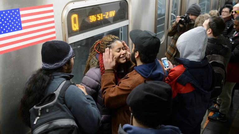 Harlem residents Frankie Santiago and Enisa DeJesus share a kiss as they wait for the doors to open on a northbound Q train during the first day of service on the Second Avenue subway on Sunday, Jan. 1, 2017.