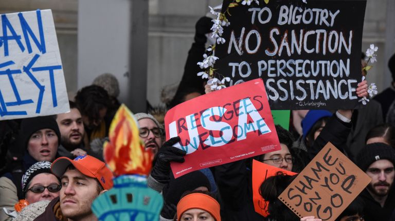 Protesters at Kennedy Airport hold signs during a rally in support of refugees and others blocked from traveling to the country by an executive order.