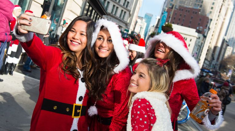 Victoria Lee, from New Jersey, takes a selfie with friends during SantaCon in Manhattan on Dec. 10, 2016.