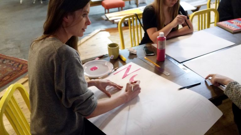 Erin Rommel, 33, of Brooklyn, and Patricia Raubo, 29, of Brooklyn, worked on signs at the other end of the table.