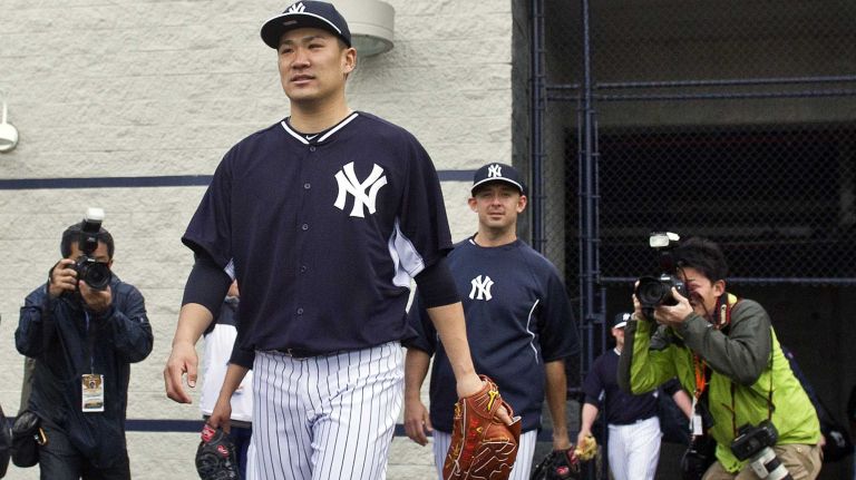 Members of the media take photographs as Yankees' Masahiro Tanaka takes the field at Steinbrenner Field in Tampa, Fla. on the morning of Feb. 15, 2014.