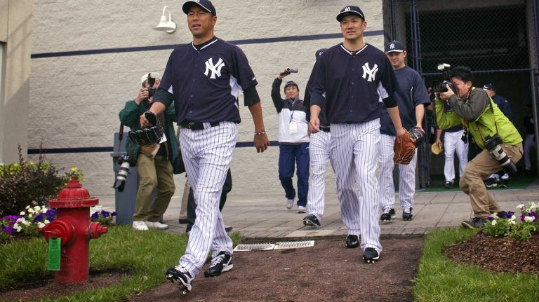 Members of the media take photographs as Yankees' Hiroki Kuroda and Masahiro Tanaka take the field at Steinbrenner Field in Tampa, Fla. on the morning of Feb. 15, 2014.