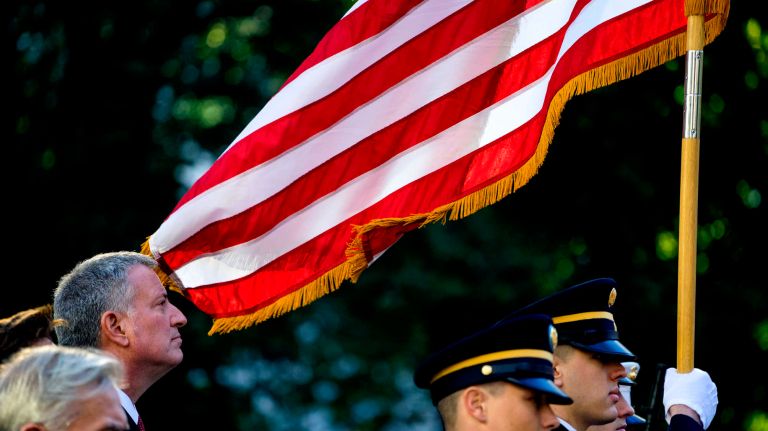 Mayor Bill deBlasio stands by as the Color Guard takes the stage in Madison Square Park for a service during the Veterans Day Parade in New York Friday, Nov 11, 2016.
