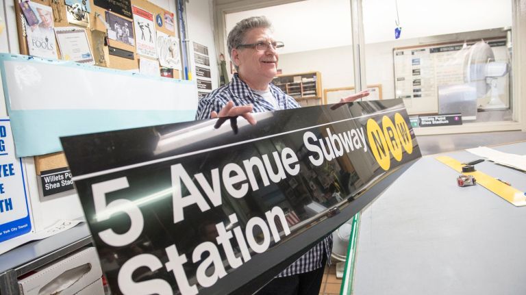 Sign fabricator Marc Lussier holds a subway sign he just finished on Tuesday, Oct. 25, 2016.