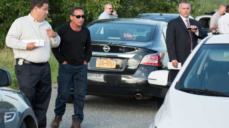 Karina Vetrano's father, Philip, seen above wearing a black shirt, joins police as they investigate the homicide scene at the marsh at Spring Creek Park near the Belt Parkway.