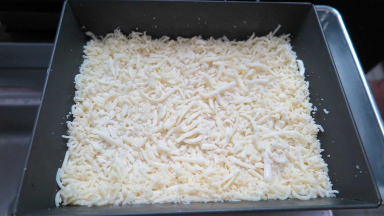 Each PepperNoni pie at Emmy Squared begins this way -- with dough and lots of cheese inside a square pan.