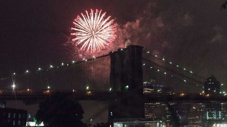 People watch the Macy's 4th of July Fireworks from Brooklyn Bridge Park on July 4, 2016.
