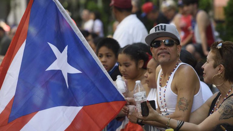 Spectators line Fifth Avenue as they wait for the start of the 59th Annual Puerto Rican Day Parade in Manhattan on Sunday, June 12, 2016.