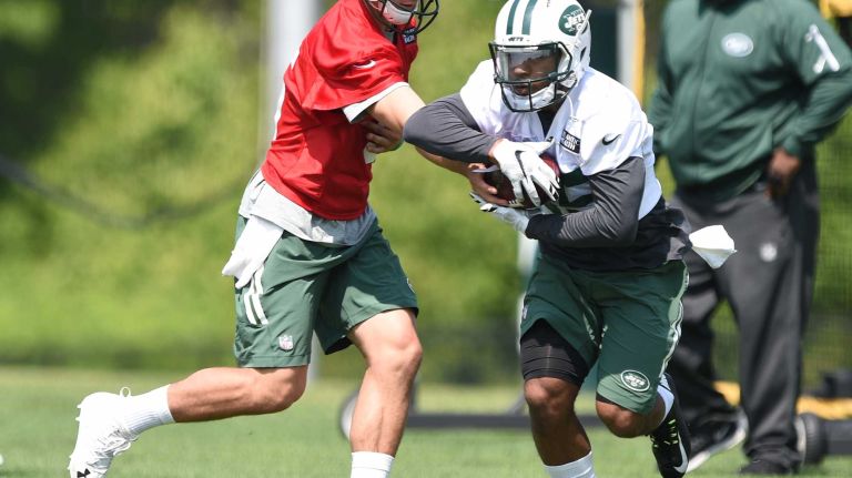 New York Jets quarterback Christian Hackenberg hands the ball off to Jets running back Dominique Williams during Organized Team Activities at the Jets Training Center on Wednesday, May 25, 2016.