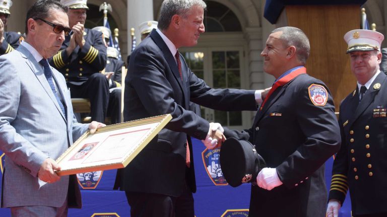 FDNY firefighter William Willets, of Mastic, shakes hands with New York City Mayor Bill de Blasio after receiving the M.J. Delehanty Medal Medal during the FDNY Medal Day Ceremony in front of City Hall in Manhattan on Wednesday, June 01, 2016. Firefighter Willets rescued a woman who had been stabbed from a burning apartment in the Bronx.