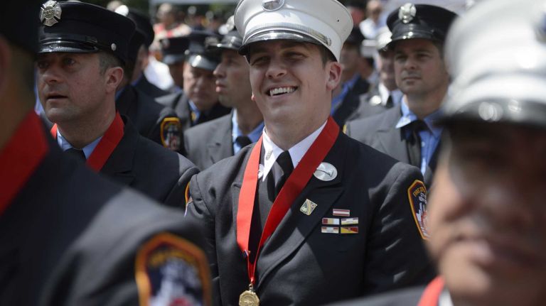 FDNY Lt. John Haseney, of West Islip, center, smiles after receiving the Henry D. Brookman Medal during the FDNY Medal Day Ceremony in front of City Hall in Manhattan on Wednesday, June 01, 2016. Lt. Haseney, a former member of the New York Army National Guard who was deployed to Afghanistan in 2008, rescued a woman during a fire in Queens in 2015.