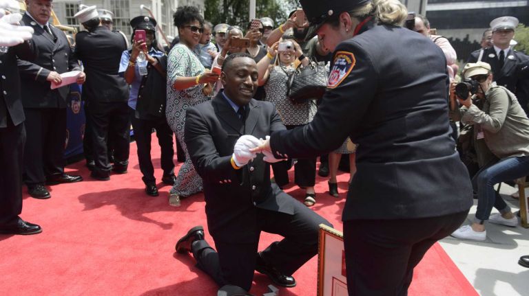 FDNY Rescue Paramedic Makesi Oliver, of the Bronx, proposes to Paramedic Cristina Aponte following the FDNY Medal Day Ceremony outside City Hall in Manhattan on Wednesday, June 01, 2016. Paramedic Aponte was one of five people to receive the Chief James Scullion Medal.
