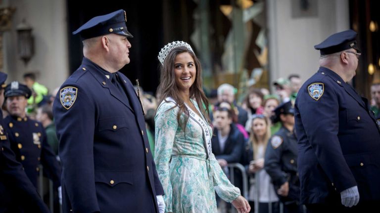Miss New York USA 2016 Serena Bucaj marches up Fifth Avenue with police officers during the St. Patrick's Day Parade in Manhattan on March 17, 2016.