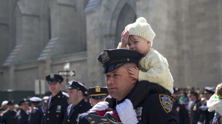 New York City Police Department members march with their loved ones on Fifth Avenue during the St. Patrick's Day Parade in Manhattan on March 17, 2016.