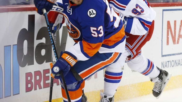 Casey Cizikas #53 of the New York Islanders plays the puck in the first period against Keith Yandle #93 of the New York Rangers at Barclays Center on Wednesday, Dec. 30, 2015 in Brooklyn, New York.