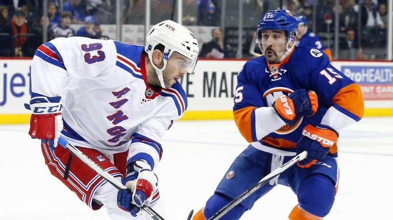 Keith Yandle #93 of the New York Rangers plays the puck in the first period against Cal Clutterbuck #15 of the New York Islanders at Barclays Center on Wednesday, Dec. 30, 2015 in Brooklyn, New York.