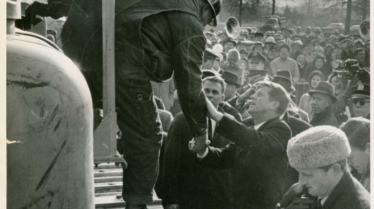 President John F. Kennedy shakes hands with the driver of a tractor used to break ground at the Worlds Fair in Flushing in December 1962.