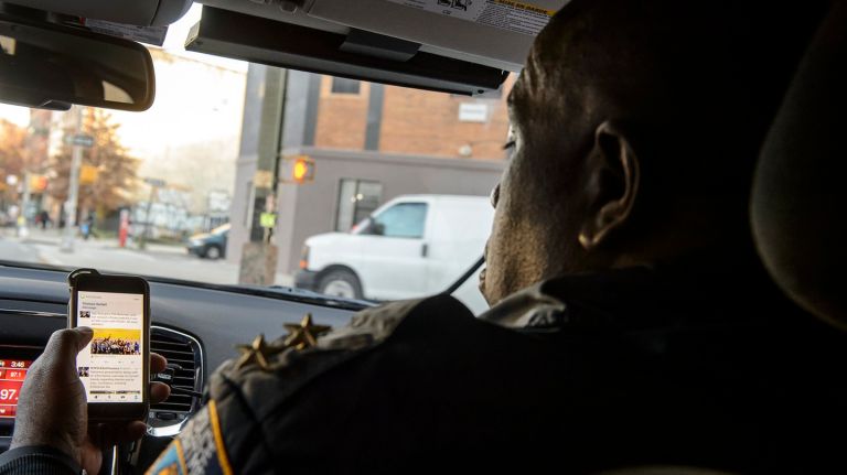 NYPD Assistant Chief Jeffrey Maddrey, Commanding Officer of Patrol Borough Brooklyn North, checks the Twitter feeds of precincts under his command while on patrol, Thursday, Nov. 17, 2016.