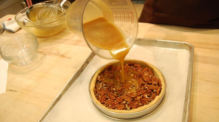 Pour your filling over the pecans until the shell is filled. Don't pour all in one place.<strong>Pro tip:</strong> use a measuring cup to make pouring easy.