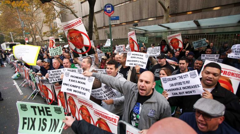 NYC Patrolmen’s Benevolent Association members carry signs that express their dissatisfaction over a proposed 1 percent raise on Thursday, Nov. 5, 2015 in Manhattan.