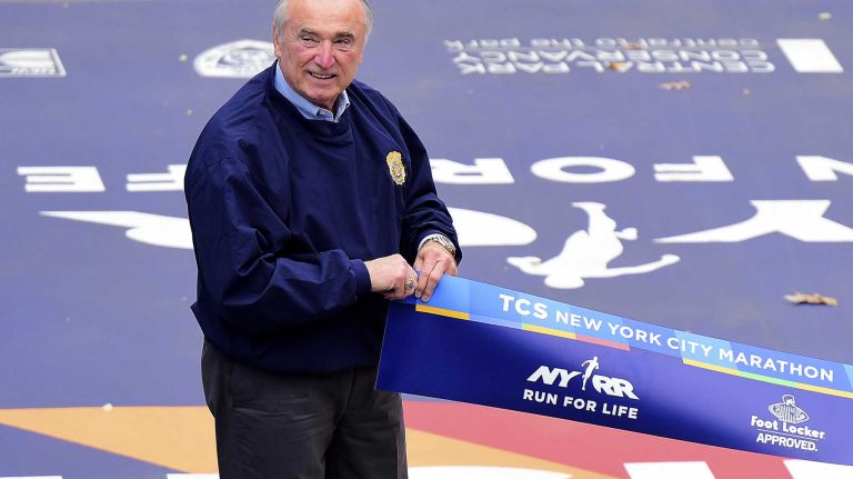 NYPD Commissioner William J. Bratton holds the finish line tape for the Men's New York City Marathon in Manhattan on Sunday, Nov. 1, 2015.