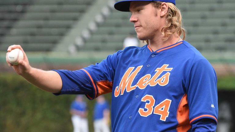 New York Mets starting pitcher Noah Syndergaard (34) looks at a ball during warmups during Game 4 of the NLCS against the Chicago Cubs at Wrigley Field on Wednesday, Oct. 21, 2015.