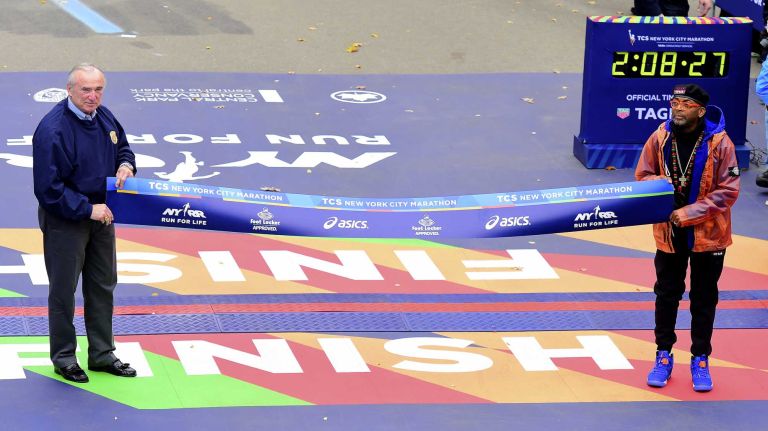 NYPD Commissioner William J. Bratton and film director Spike Lee hold the finish line tape for the Men's New York City Marathon in Manhattan on Sunday, Nov. 1, 2015.