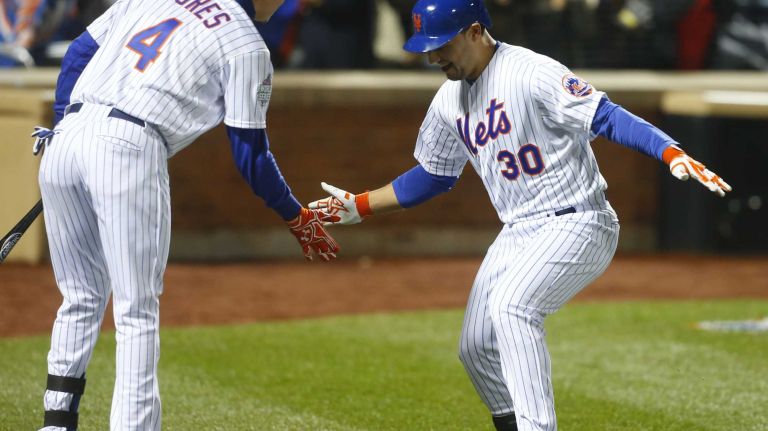 New York Mets shortstop Wilmer Flores (4) low fives New York Mets left fielder Michael Conforto (30) after his fifth inning homerun during Game 4 of the World Series against the Kansas City Royals at Citi Field on Saturday, Oct. 31, 2015.