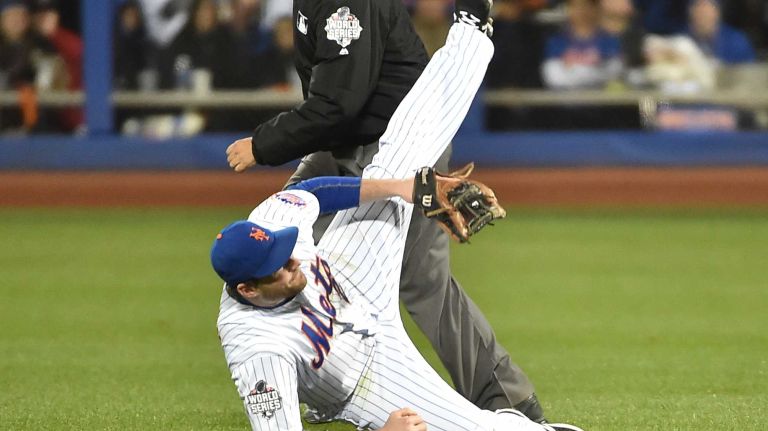 New York Mets second baseman Daniel Murphy tries to make a play on a ball hit by Kansas City Royals third baseman Mike Moustakas in the sixth inning during Game 3 of the World Series against the Kansas City Royals at Citi Field on Friday, Oct. 30, 2015.