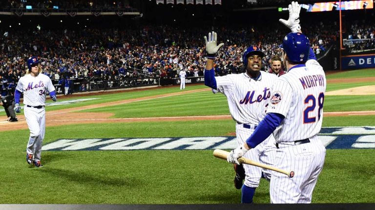 New York Mets right fielder Curtis Granderson comes to the dugout as he high fives second baseman Daniel Murphy (28) after his third inning home run during Game 3 of the World Series against the Kansas City Royals at Citi Field on Friday, Oct. 30, 2015.